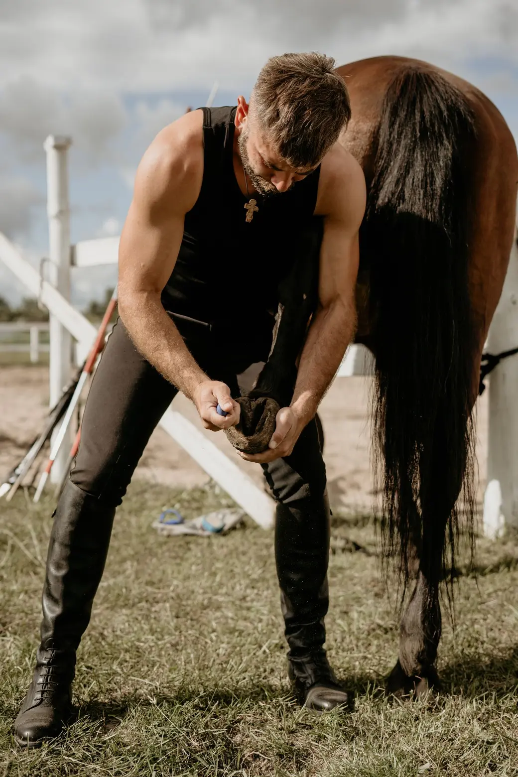 Farrier caring for a horse hoof outdoors